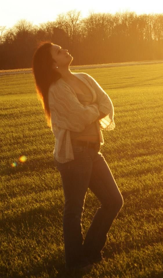 Silhouette of a person posing in a field during golden hour sunset.