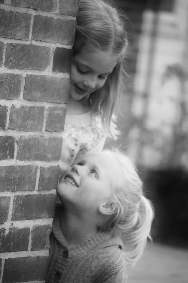 Black and white photo series of two children laughing and playing together.