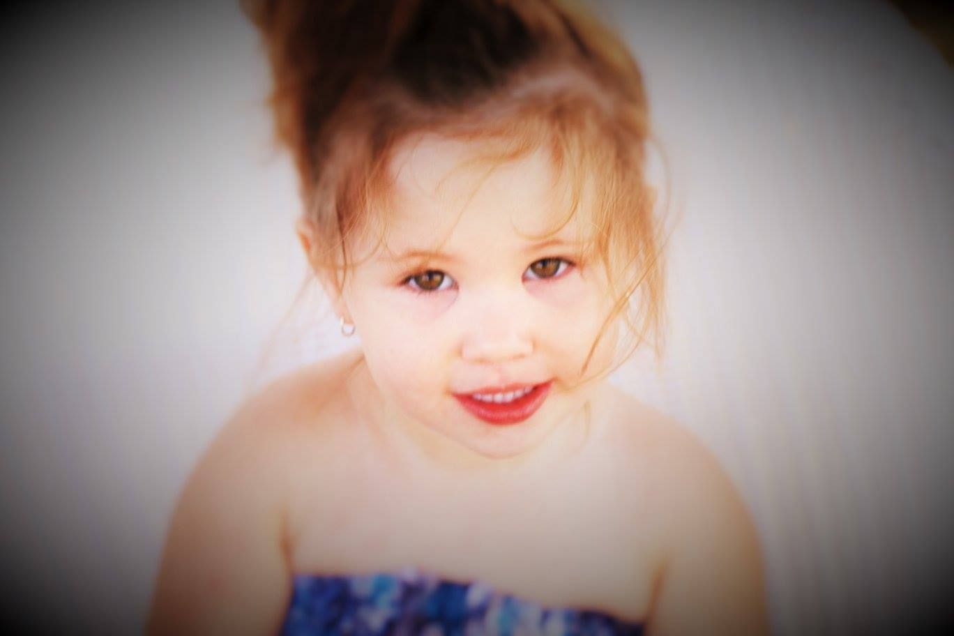 Soft focus portrait with vignette effect and blue clothing detail.