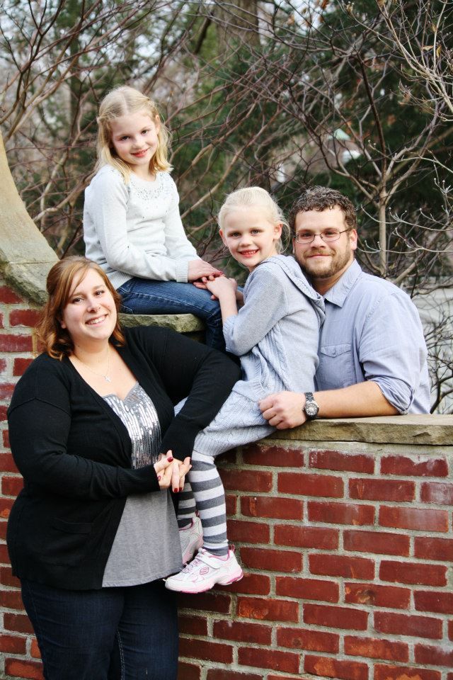 Family portrait session on brick wall with winter clothing and natural backdrop.