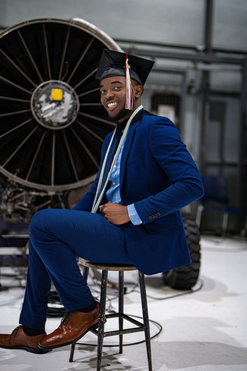 Graduate posing with cap and gown — milestone portrait by Timoy B Photography.
