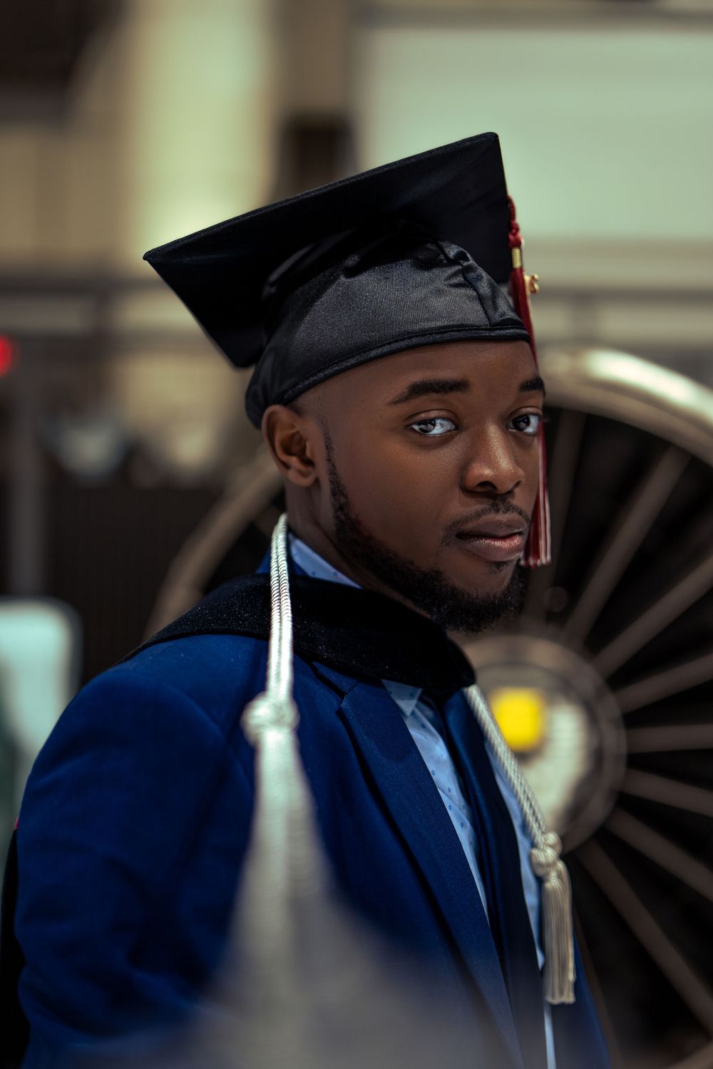 Graduate posing with cap and gown — milestone portrait by Timoy B Photography.
