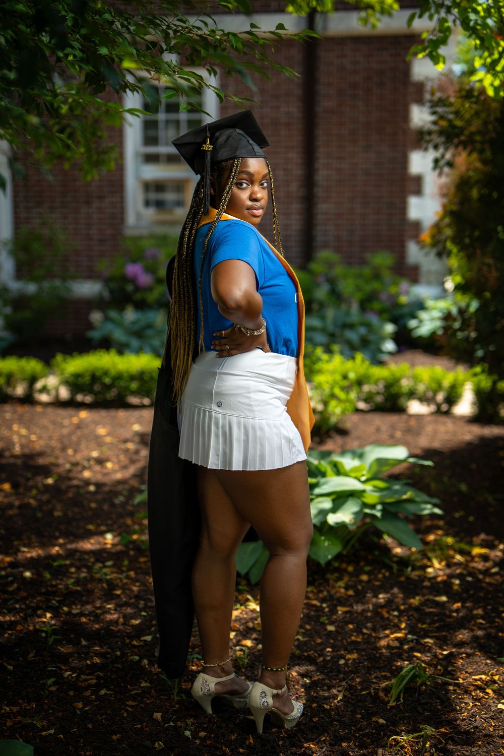 Graduate posing with cap and gown — milestone portrait by Timoy B Photography.
