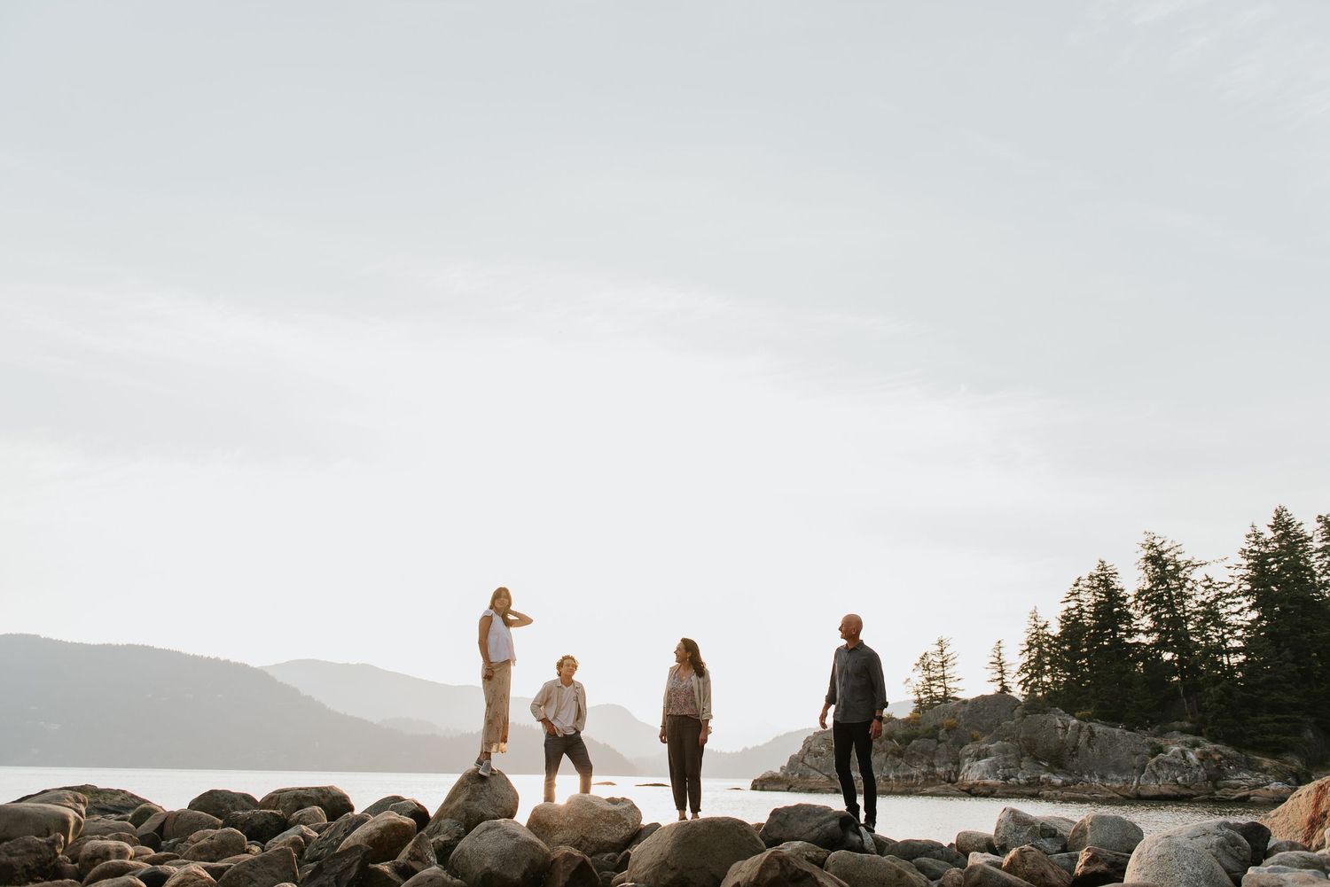 Family of four with two teenagers standing on rocks at WhiteCliff Park in West Vancouver