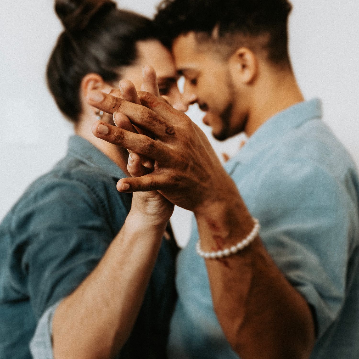 Intimate moment between couple holding hands while dancing together.