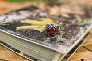 Vintage photos spread out on wooden surface with decorative ring detail.