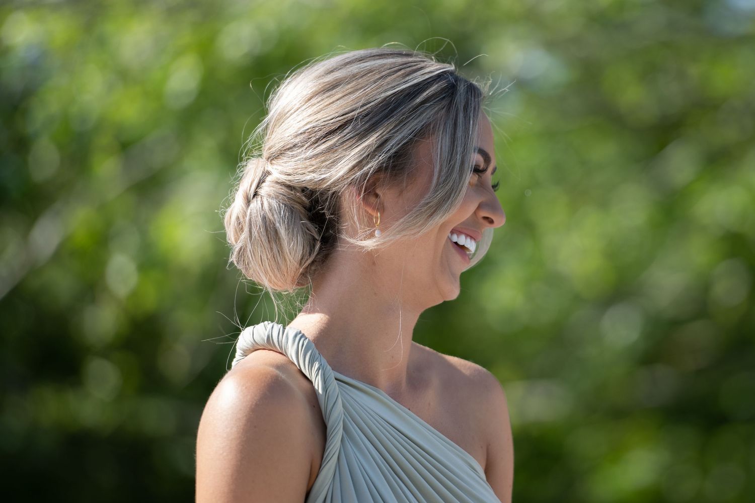 Candid moment of joyful laughter against green garden background.