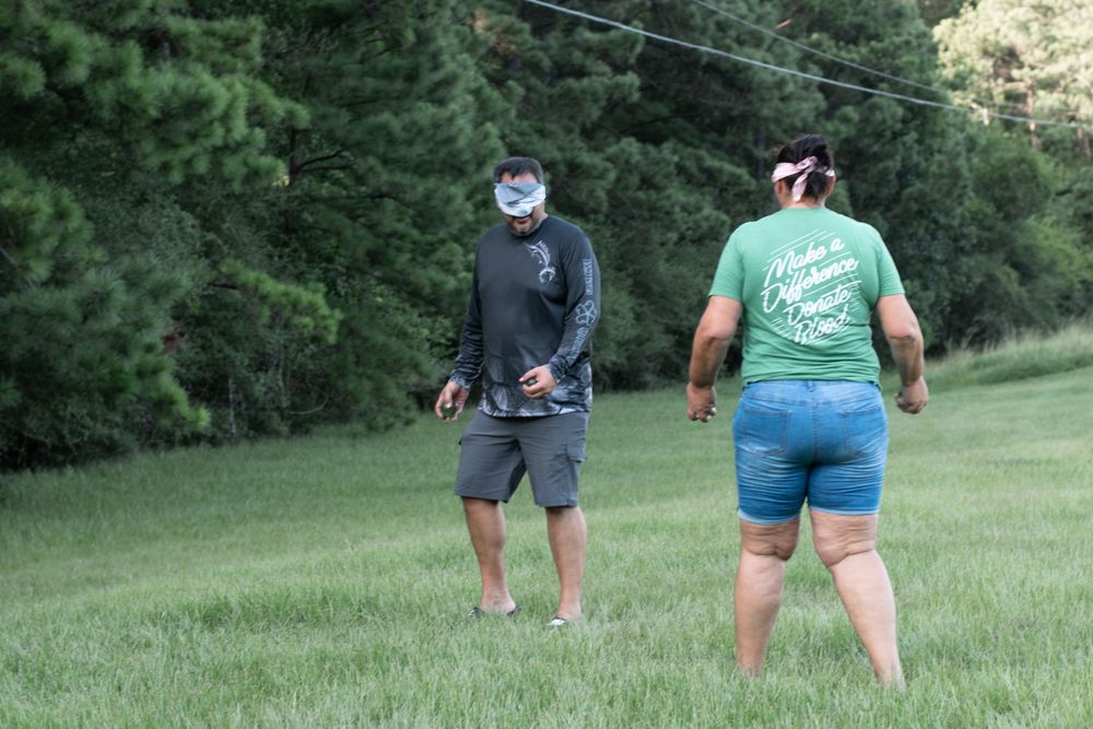Two people enjoying outdoor activities in a scenic grassy field.