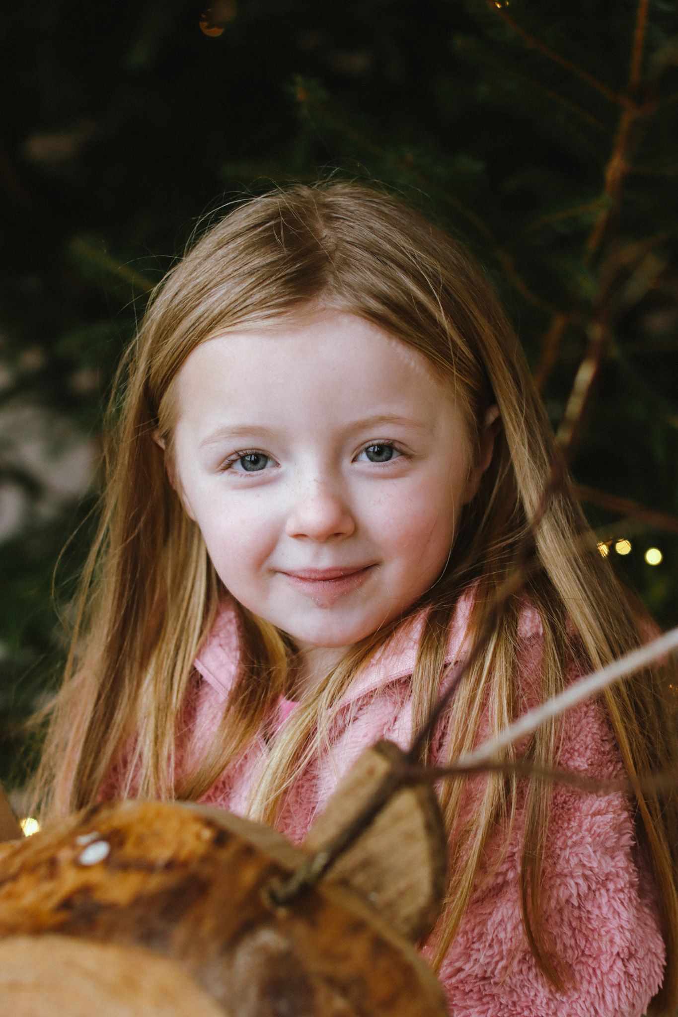 Sweet portrait in natural lighting showing pink clothing and log setting.