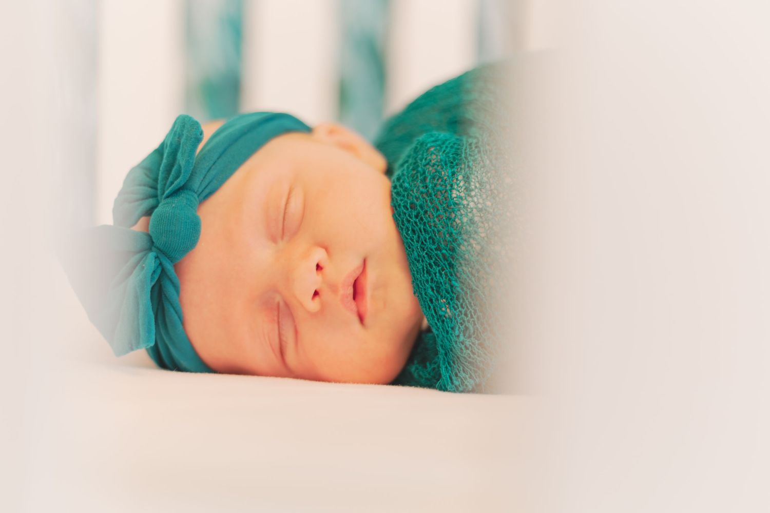 Soundly sleeping in her crib, this baby is wrapped in vibrant green swaddles