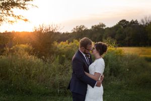 Romantic sunset wedding photography session in a golden field at dusk.