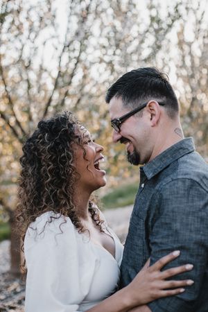 couple embracing in a almond orchard while in bloom