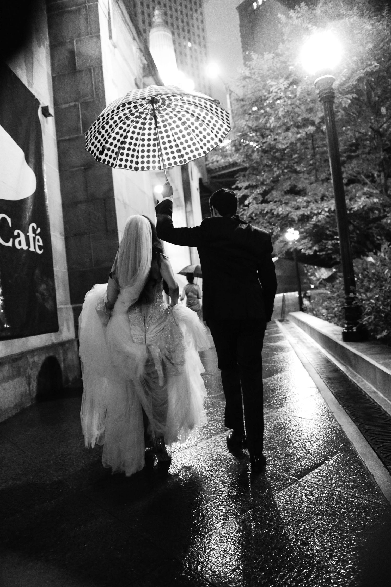 Rainy night wedding photos with umbrella silhouettes creating a moody atmosphere.