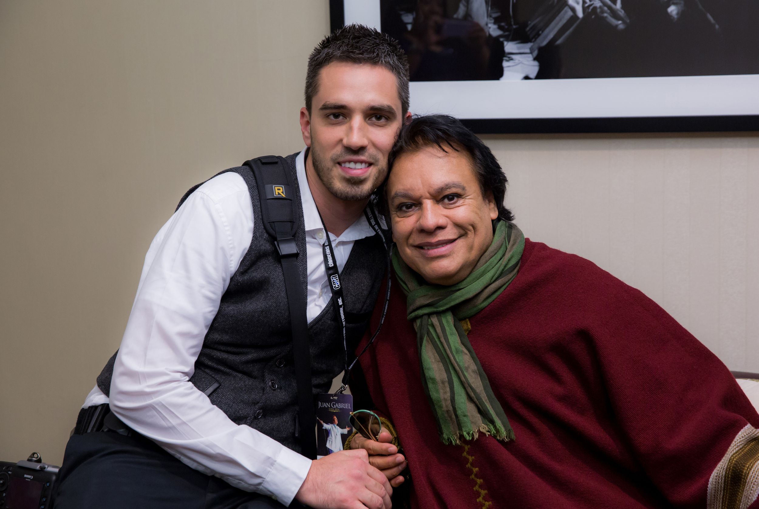 Two people relax on a couch wearing casual winter clothing including a burgundy sweater and green scarf.