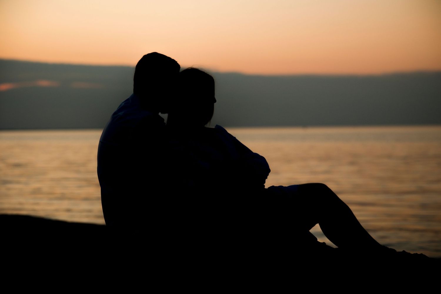 Silhouette of engaged Kayla and Zach at sunset on Delaware beach Lewes