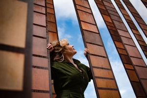 Woman looks up toward the sky while standing in the middle of an art exhibit @ Seattle Center during a branding shoot.