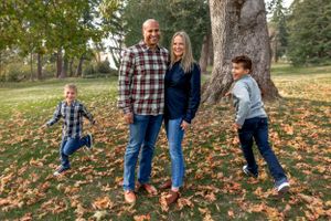 Two kids run circles around their parents during a fall photo shoot in Lincoln Park, West Seattle.