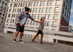 A couple dances on the rooftop of the Butler Parking Garage in Seattle, Washington during a family photo shoot.