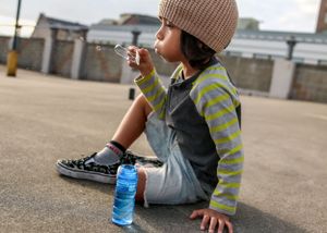 A small child sits and blows bubbles on the Butler Garage rooftop in downtown Seattle during a family photo shoot.