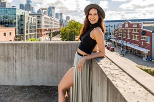 Dancer leans against a concrete wall with Seattle buildings in the background during a dance shoot @ Sculpture Park