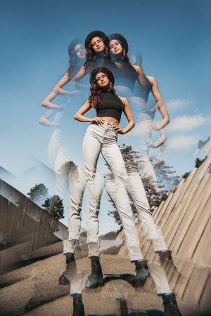 Kaleidoscope image of a dancer and model standing with hands on hips, wearing a black hat at the Sculpture Park, Seattle