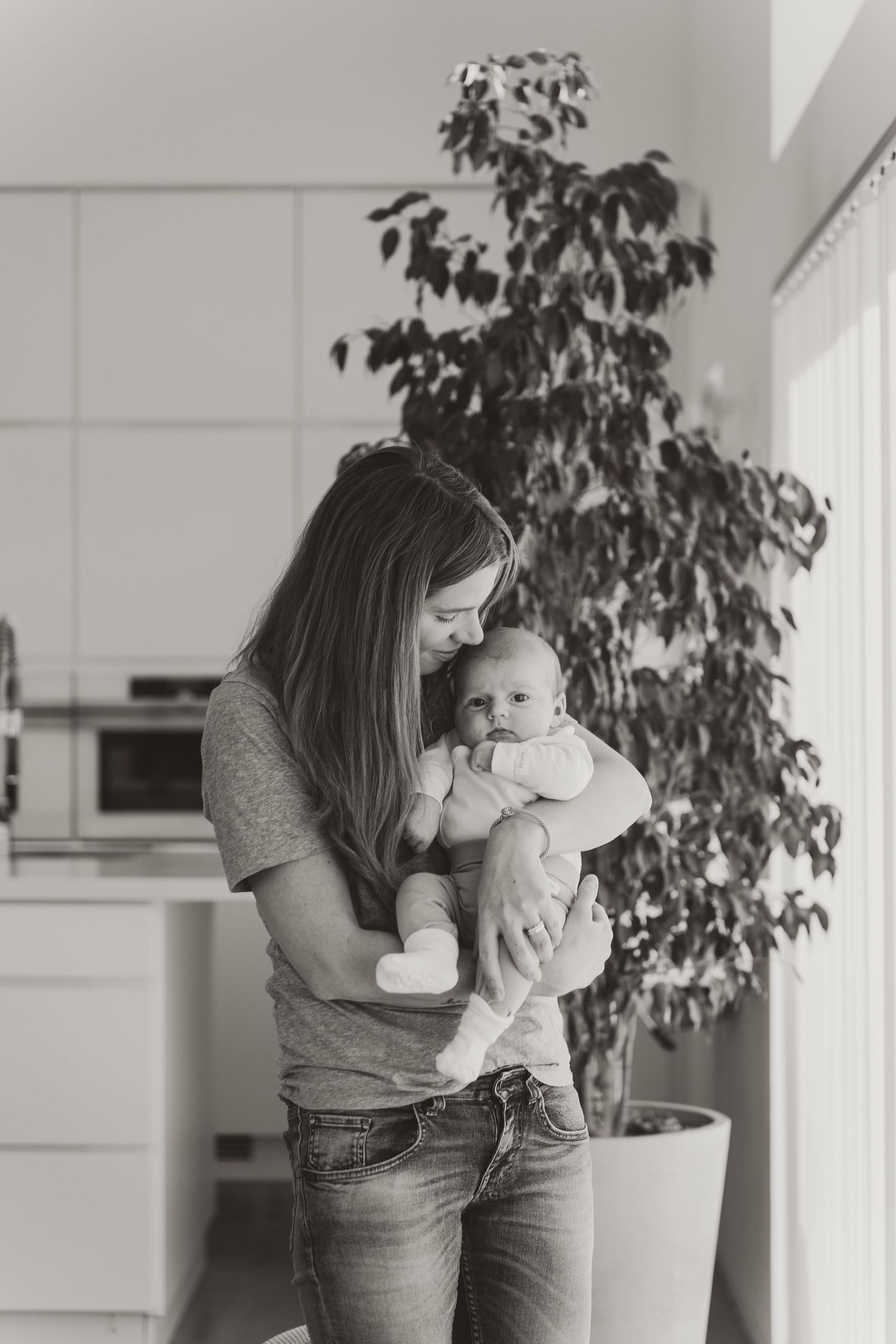 Black and white portrait in a modern kitchen with indoor plants.
