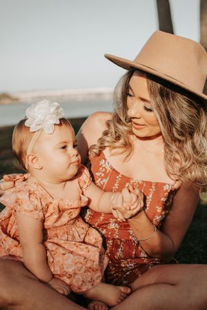 Candid moments between parent and child wearing matching peach outfits during sunset.