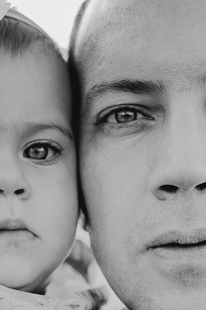 Close-up black and white portrait showing loving connection between parent and child.