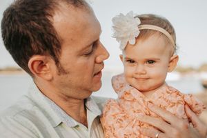 Golden hour family photoshoot on beach showing tender moments.