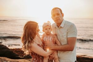 Family enjoying sunset moment together at beach.