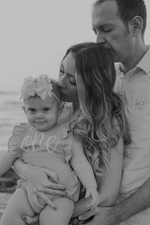 Black and white family portrait series at beach.
