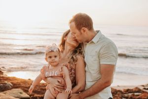 Sunset beach family photoshoot with warm golden light.