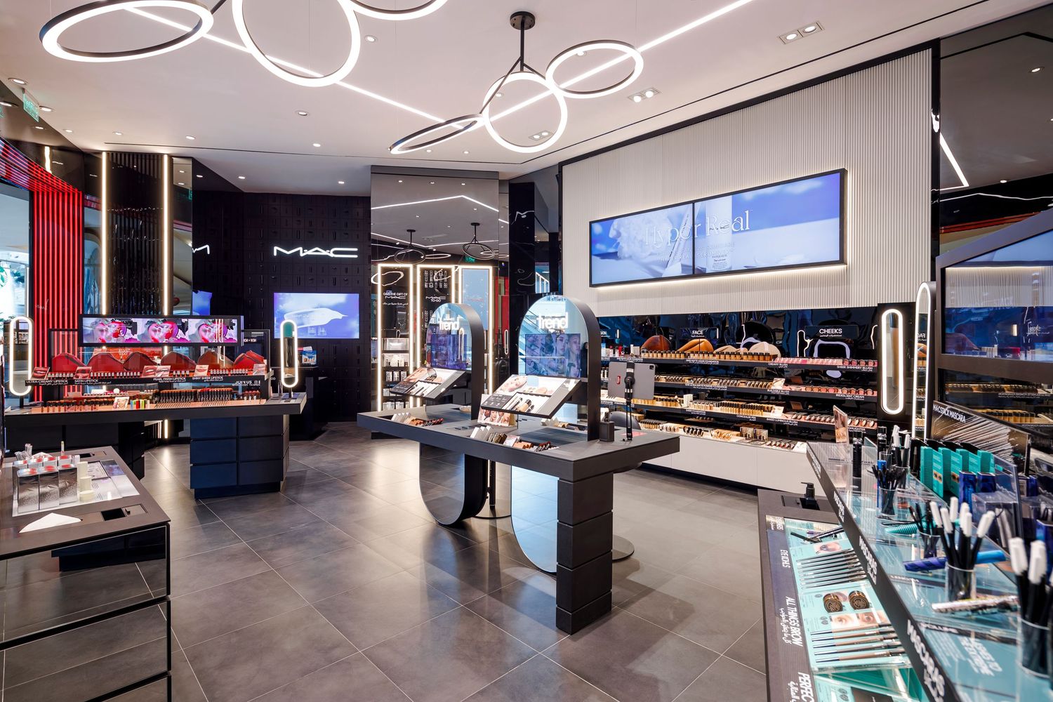 Interior of MAC makeup store showing product displays and modern lighting fixtures.