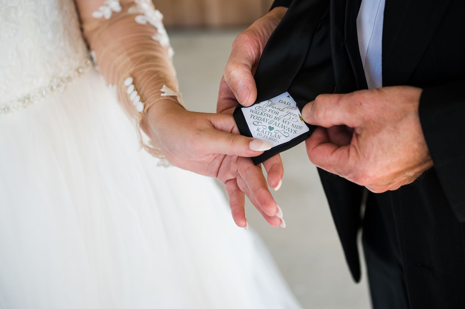 bride shows a note she wrote on the back of her dad's tie