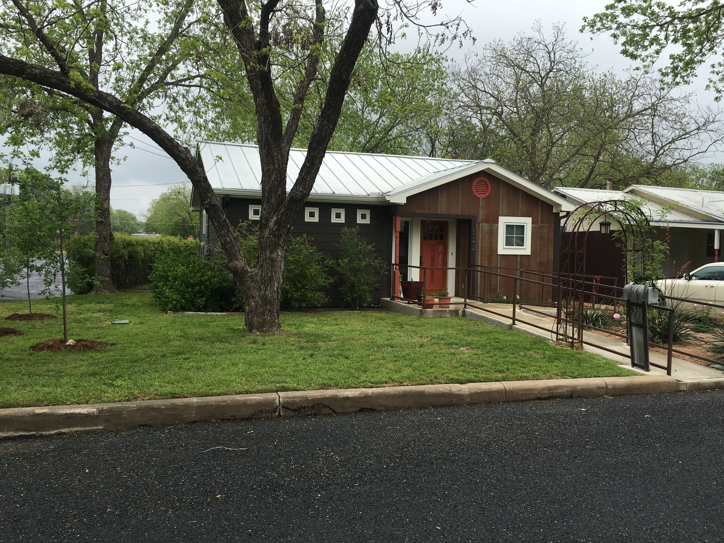 A series of red and brown buildings with ramps and walkways nestled among trees on a hillside property.
