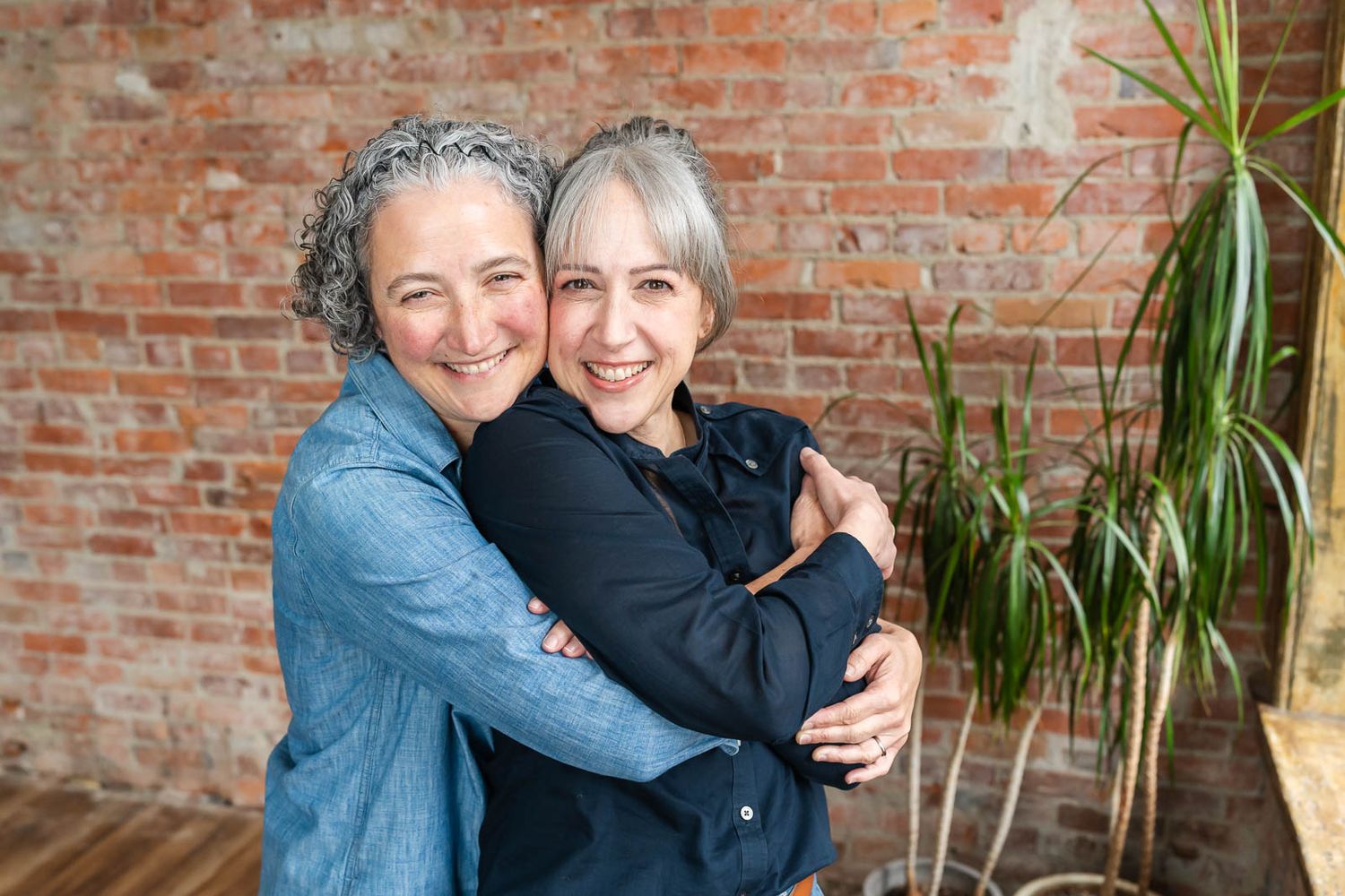 Adult sisters hugging and smiling for the camera in Seattle.