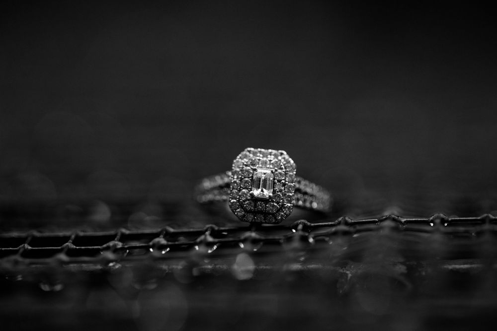 Diamond engagement ring with intricate details captured in dramatic black and white.