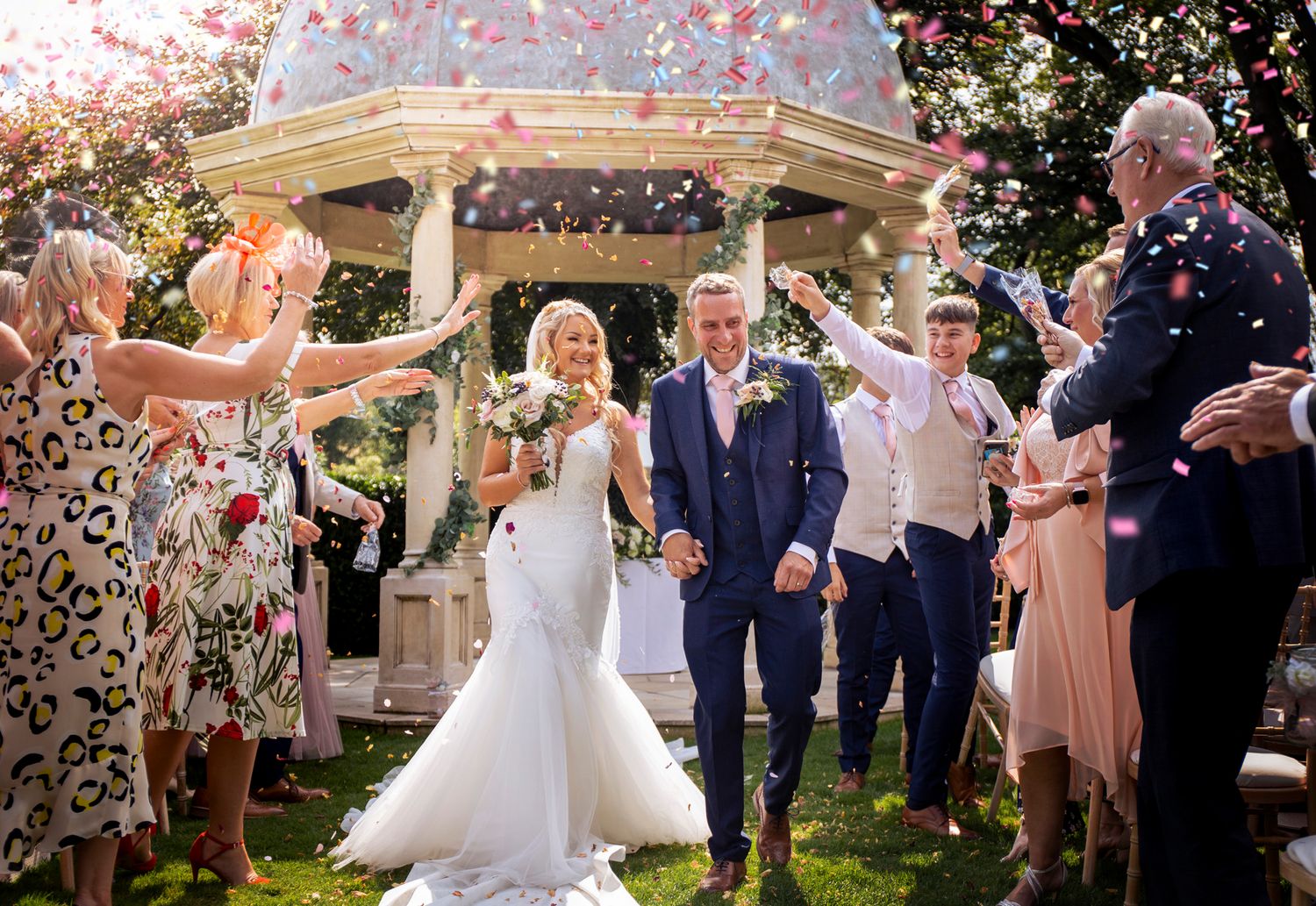 bridge and groom walk through an avenue of multicolour confetti at wentbridge house
