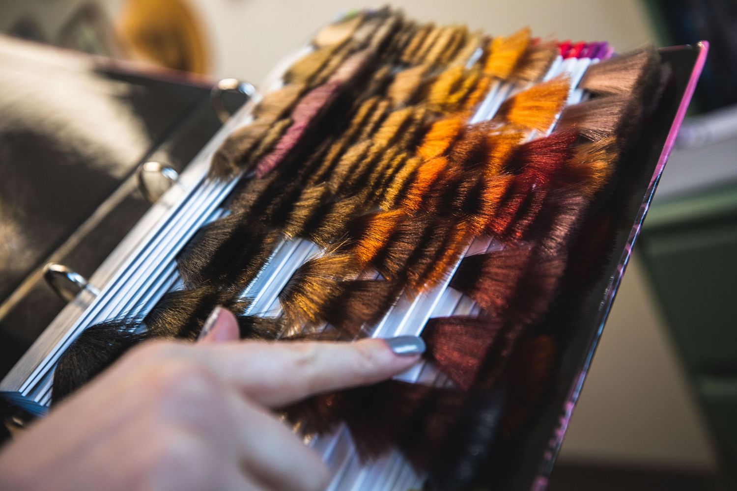 Hand flipping through pages of a photo album with warm lighting effects.