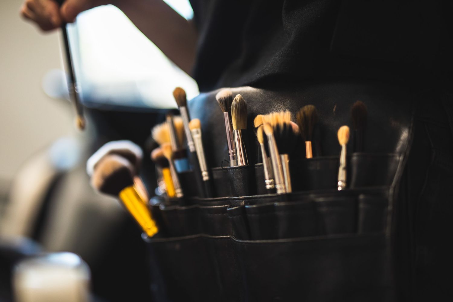 Professional makeup brushes arranged in a black organizer against a neutral background.