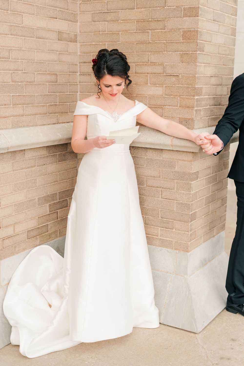 Bride and groom during their first touch on the steps at Holy Family Cathedral, Tulsa, OK before their wedding.