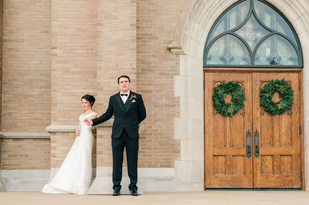 Bride and groom during their first touch on the steps at Holy Family Cathedral, Tulsa, OK before their wedding.