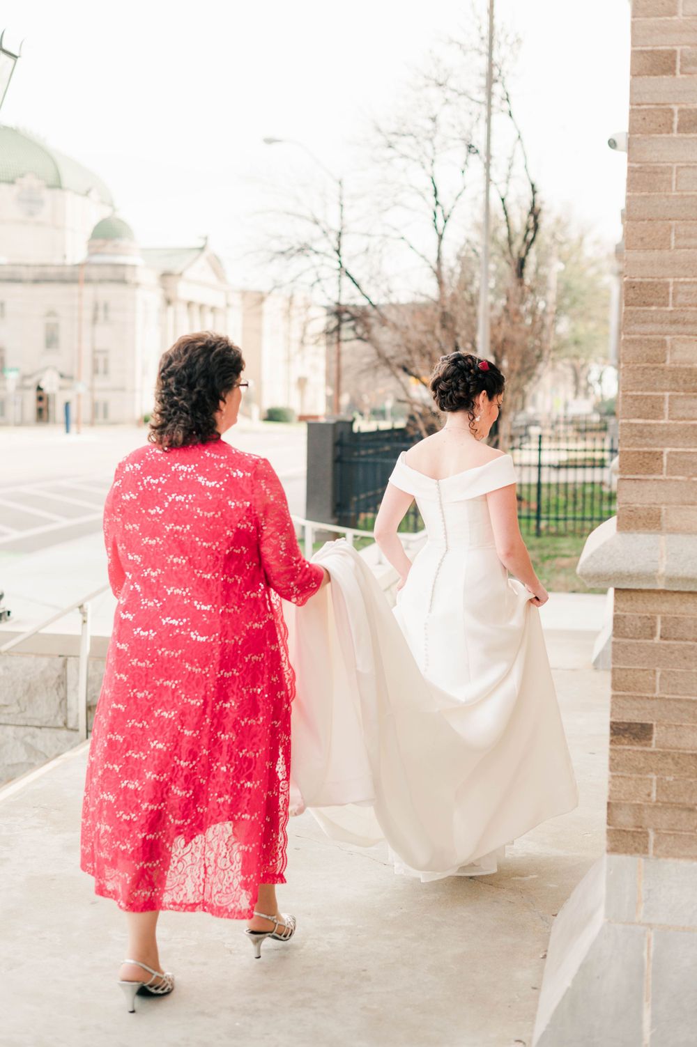 Bride and groom during their first touch on the steps at Holy Family Cathedral, Tulsa, OK before their wedding.
