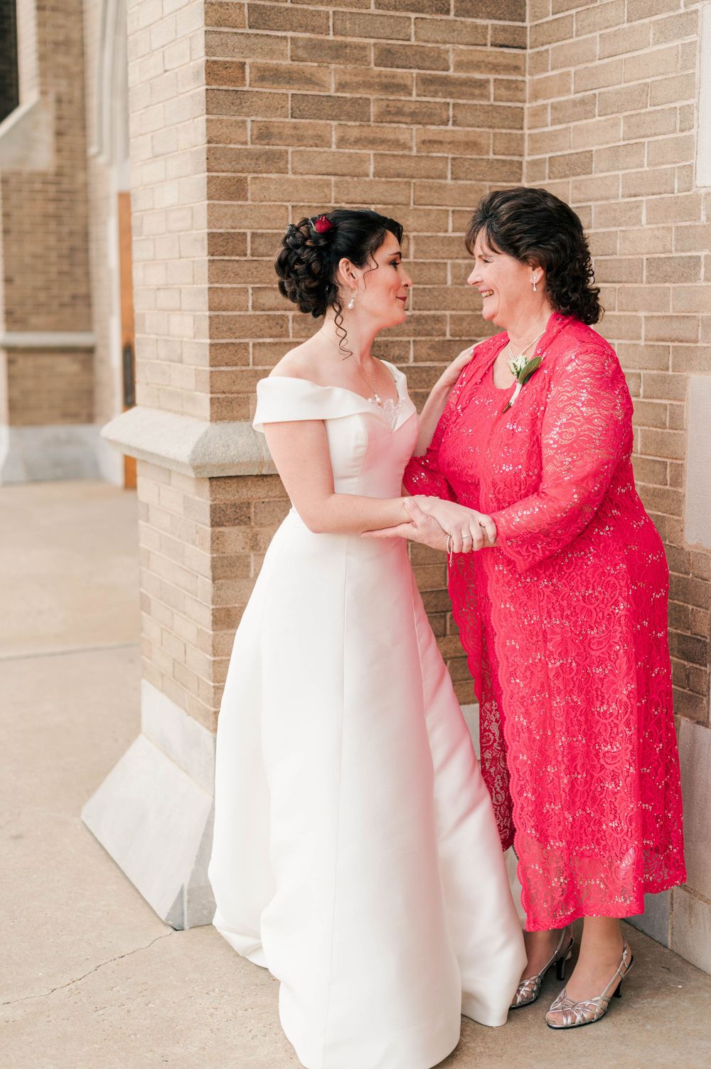 Bride and groom during their first touch on the steps at Holy Family Cathedral, Tulsa, OK before their wedding.