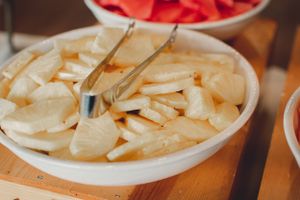 A bowl of sliced white potato pieces served at what appears to be a buffet table.