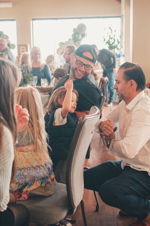 A joyful moment captured during an indoor celebration with bright natural lighting.
