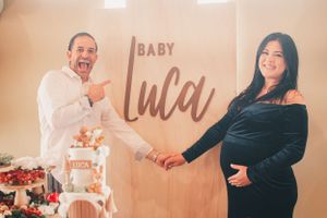 Baby shower celebration with decorative sign reading 'Baby Luca' and festive party setup.