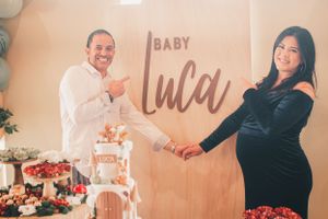 Joyful baby shower celebration with 'Baby Luca' sign and elegant party decorations.