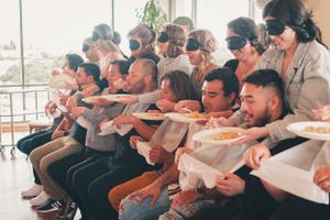 Guests seated in rows participate in a fun activity during an indoor celebration.