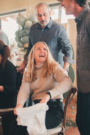 A joyful celebration moment at a social gathering with guests laughing and having fun.